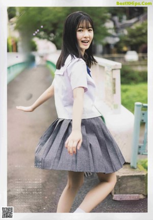 A woman in a school uniform holding a fishing rod.