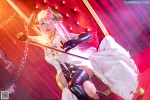 A woman with pink hair holding a sword.