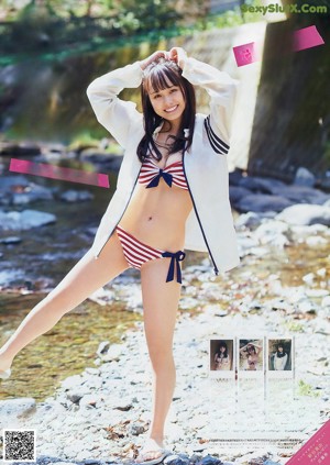 A woman in a blue bathing suit sitting by a pool.