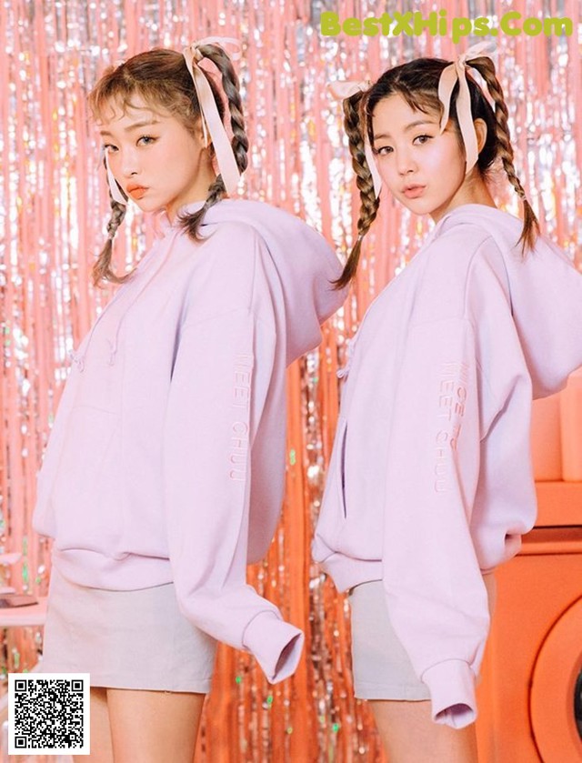 two girls in pink sweatshirts standing next to each other