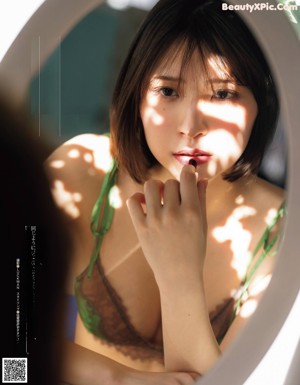 A woman in a green lingerie laying on a bed.