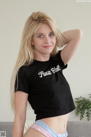 A woman in a white sweater is posing for a picture.