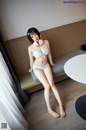 A naked asian woman wearing a pink cat ears headband.