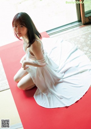 A woman in a red bathing suit is posing for a picture.