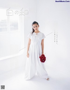 A woman in a white dress is posing for a magazine.