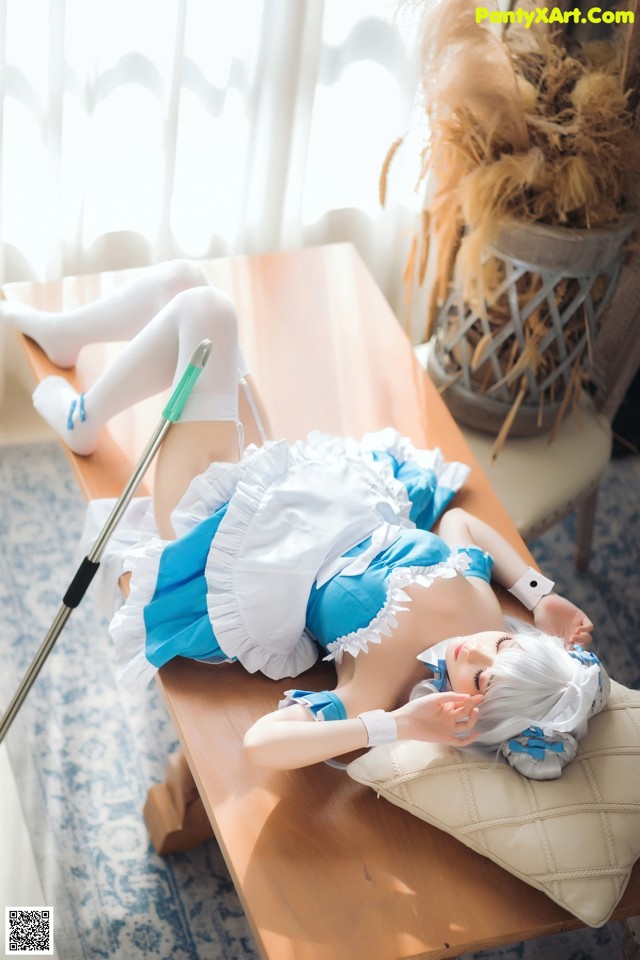A woman laying on top of a wooden table.