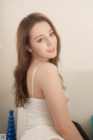A naked asian woman posing on a white couch.
