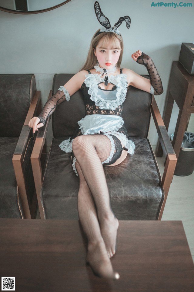 A woman in a bunny costume sitting on a chair.