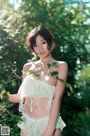 A woman in a white lingerie standing in the woods.