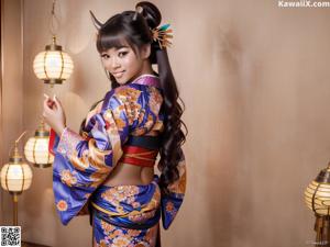 A woman in a blue kimono posing for the camera.