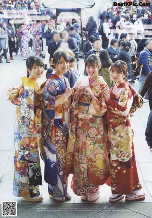 A group of young women in kimonos posing for a picture.