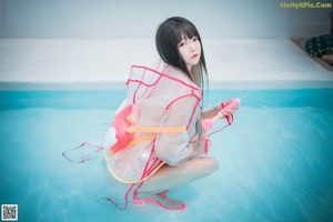 A woman in a bikini sitting in a pool of water.