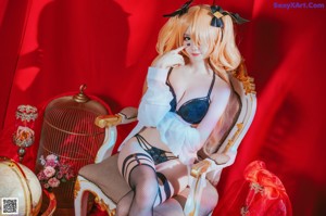 A woman in fishnet stockings sitting on a chair.