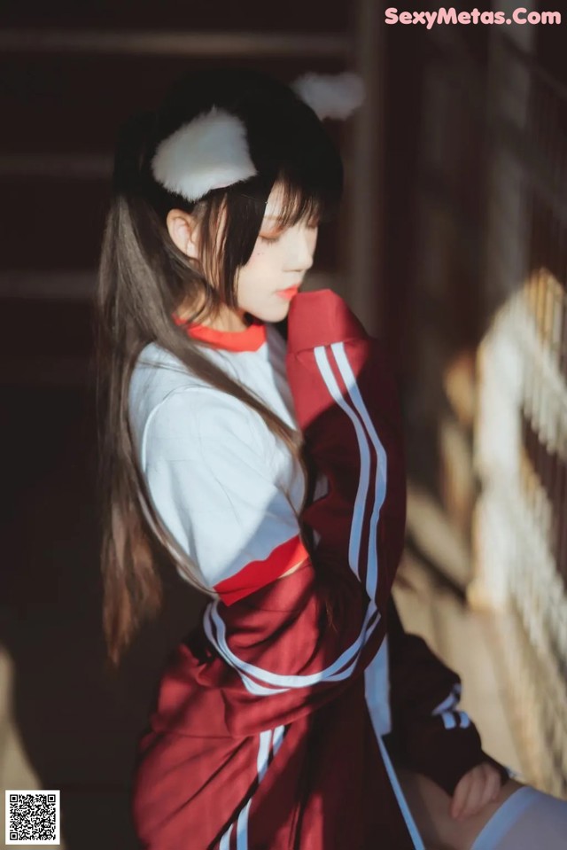 A woman in a red and white uniform sitting on a stairway.