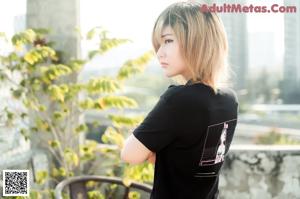 A woman wearing a black shirt and a face mask.