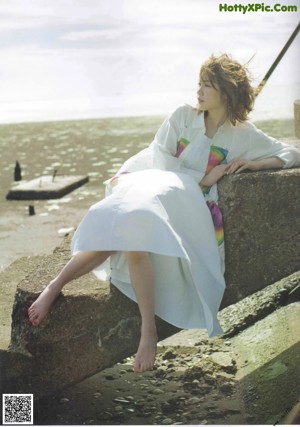 A woman with long brown hair is looking up at the sky.