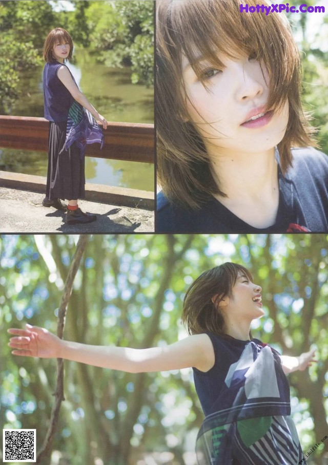 A woman standing on a bridge with her arms outstretched.