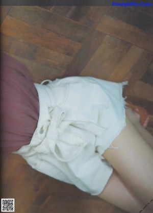 A young woman laying on top of a wooden table.