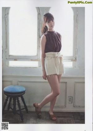 A young woman laying on top of a wooden table.