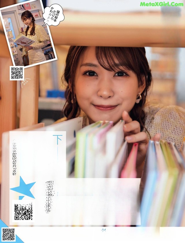 A young woman holding a stack of books in her hands.