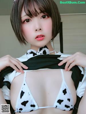 A woman in a white shirt and bunny ears sitting on a couch.