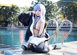 A woman with blue hair wearing a black and white jacket.