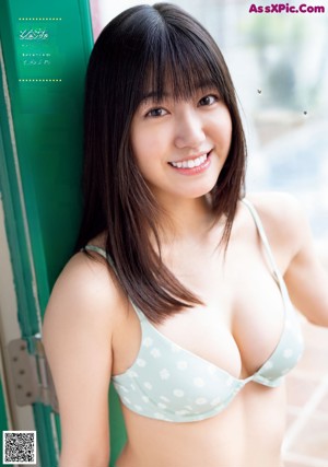 A woman in a white bodysuit leaning against a curtain.