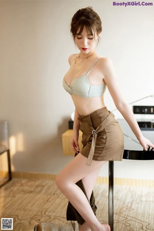 A woman in a blue lingerie sitting at a table.